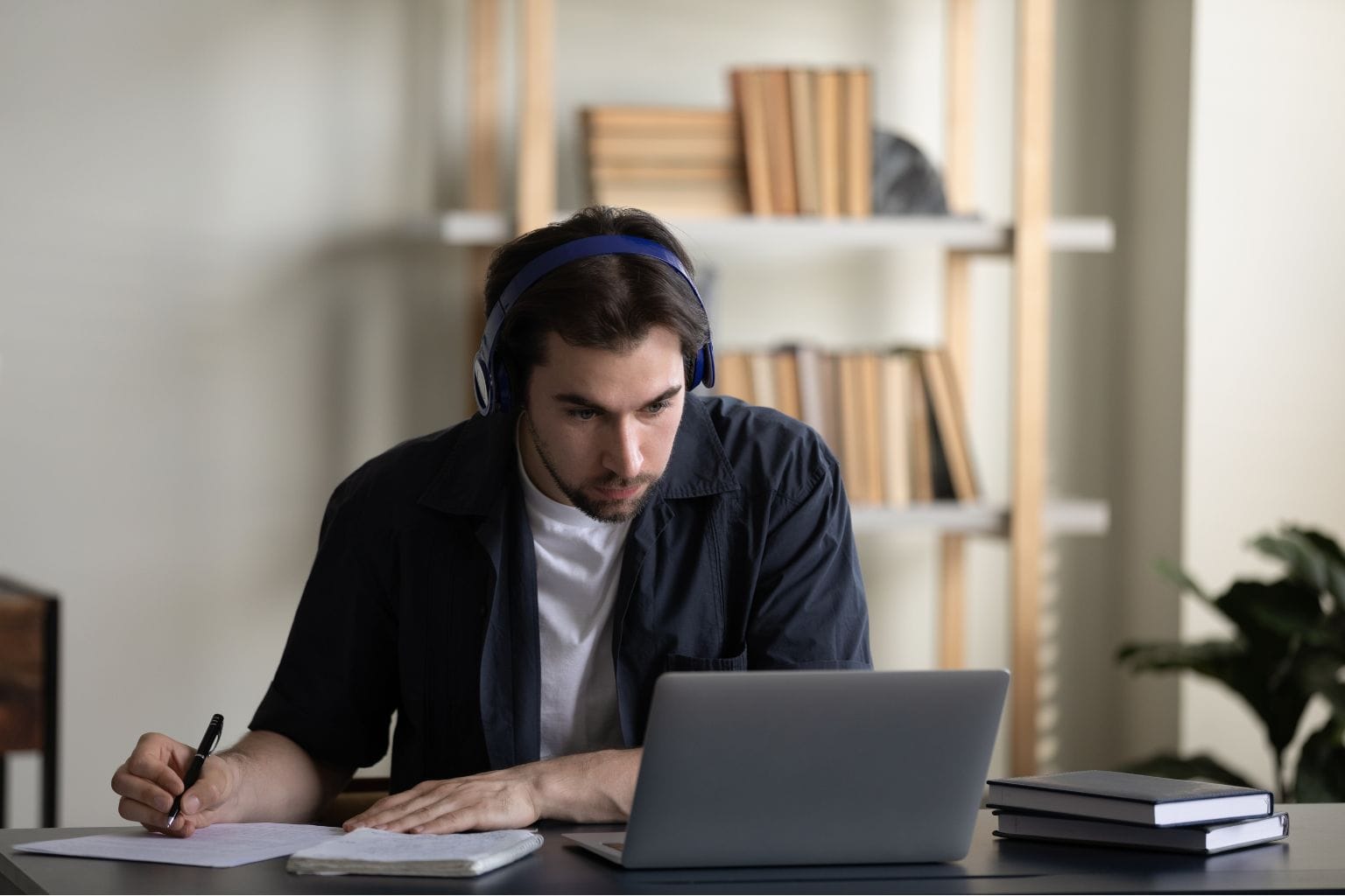 A man working on laptop with headphones on
