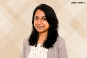 Sangeeta Bavi's portrait and anthropic logo with beige geometric background.