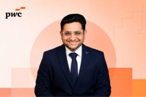 Professional corporate portrait of Syed Amir Najme centered against a minimalist geometric background in warm peach and orange tones inspired by PwC branding, featuring subtle abstract shapes and a clean editorial-style composition with the PwC logo in the corner.
