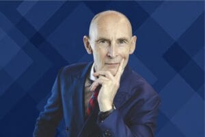 Nigel Green portrait on a deep blue geometric pattern background